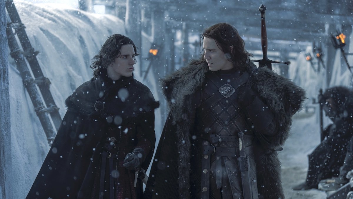 Jace e Lord Cregan conversam enquanto caminham entre a neve que cai no topo da Muralha na Casa do Dragão