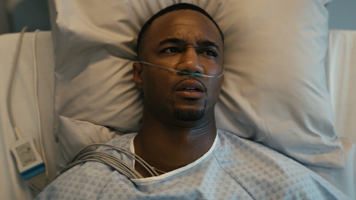 A-Train deitado em uma cama de hospital após seu transplante de coração no The Boys